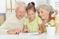 Portrait of grandparents with granddaughter using tablet Royalty Free Stock Photo