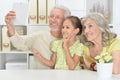 Portrait of grandparents with her granddaughter taking selfie