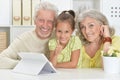 Portrait of grandparents with her granddaughter using tablet Royalty Free Stock Photo