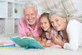 Grandparents reading book with little granddaughter Royalty Free Stock Photo