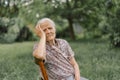 Portrait of a gray-haired adult grandmother against the background of nature.