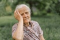 Portrait of a gray-haired adult grandmother against the background of nature.