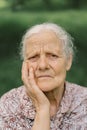 Portrait of a gray-haired adult grandmother against the background of nature.