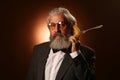 Portrait of a gray-haired elderly gentleman, with a shaggy mustache and beard, in a white shirt and gray jacket, wearing glasses Royalty Free Stock Photo