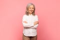 Portrait of gray haired mature woman posing with folded arms Royalty Free Stock Photo