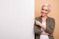 Portrait of gray short hair business woman promoting copyspace banner dynamics stats team growth isolated on beige color Royalty Free Stock Photo