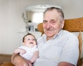 Portrait of great grandfather holding newborn baby