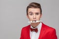 Portrait of greedy businessman holding dollar banknote with teeth, looking shocked. isolated on