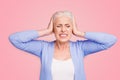 Portrait of grey haired old nice beautiful annoyed woman with palms on head. Isolated over violet purple background