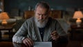 Portrait greyhaired gentleman signing contract indoors. Man reading documents. Royalty Free Stock Photo