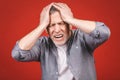 Portrait of a groggy upset worried sad, depressed, tired senior man with a headache, very stressed, isolated on red background, Royalty Free Stock Photo