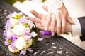 Portrait of groom holding brides hand on table near bouquet Royalty Free Stock Photo