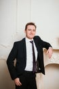 Portrait groom man in black suit on light background