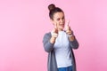 Portrait of groomed brunette teenage girl winking at camera, pointing with finger pistols. isolated on pink background