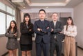 Portrait of group Asian business people in suit standing arms crossed and smiling looking on camera in office room Royalty Free Stock Photo