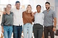 Portrait of a group of confident diverse businesspeople standing with arms around each other in an office. Happy smiling Royalty Free Stock Photo