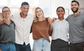 Portrait of a group of confident diverse businesspeople standing with arms around each other in an office. Happy smiling Royalty Free Stock Photo