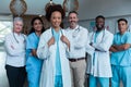 Portrait of group of diverse male and female doctors standing in hospital corridor smiling to camera Royalty Free Stock Photo