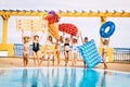 Portrait of group of female friends enjoying summer holidays in resort. Women in swimsuit posing with food designed floats.