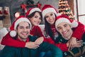 Portrait of group friendly peaceful people toothy smile cuddle enjoy magic new year time flat indoors
