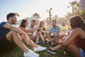 Group of friends sitting outside in circle talking