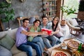 Portrait of group funky carefree friends sit sofa clink plasti beer cups enjoy free time chill house inside Royalty Free Stock Photo