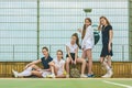 Portrait of group of girls as tennis players holding tennis racket against green grass of outdoor court Royalty Free Stock Photo