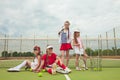 Portrait of group of girls as tennis players holding tennis racket against green grass of outdoor court Royalty Free Stock Photo