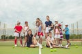 Portrait of group of girls as tennis players holding tennis racket against green grass of outdoor court Royalty Free Stock Photo