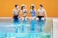 Happy teenagers sitting together in poolside Royalty Free Stock Photo