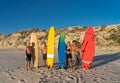 Portrait of group of mature men and woman surfers holding their surfboards on beach