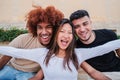 Portrait of a group of multiracial teenagers laughing and smiling together. One asian young woman spreading arms and Royalty Free Stock Photo