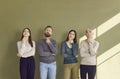 Portrait of group of people pondering or making decision while standing on green background. Royalty Free Stock Photo