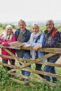 Portrait Of Group Of Senior Friends Hiking In Countryside Standing By Gate Royalty Free Stock Photo