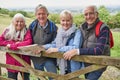 Portrait Of Group Of Senior Friends Hiking In Countryside Standing By Gate Royalty Free Stock Photo