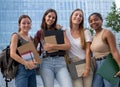 Portrait of a group of teenage student girls looking at camera smiling on a campus. Happy students at the high school Royalty Free Stock Photo