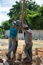 Portrait group of workers hit the concrete piles into the ground by manual steel tools at the construction site Royalty Free Stock Photo
