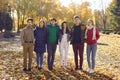 Portrait of a group of young happy smiling friends walking in the autumn park. Royalty Free Stock Photo
