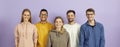 Portrait of group of young, smart and positive multiracial people on purple background. Royalty Free Stock Photo