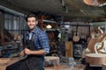 Portrait of guitar luthier small business owner in workroom