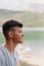 portrait of a guy on the background of a mountain lake