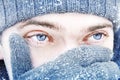 Portrait of a guy with blue eyes against a background of falling snow. Beautiful snowy weather. Snowing. Christmas image