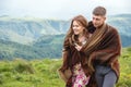 Portrait of a guy with a girl covered up with a rug embrace along a country road Royalty Free Stock Photo