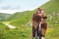 Portrait of a guy with a girl covered up with a rug embrace along a country road Royalty Free Stock Photo