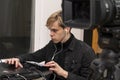 Portrait of a guy video engineer 20-25 years old, conducts an online broadcast on the Internet against the background of a video c