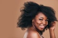 Portrait, hair care and black woman with smile, beauty and wellness on a brown studio background. Mockup space, person Royalty Free Stock Photo