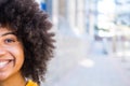 Portrait of half a face of one young beautiful cheerful African or American woman looking at the camera smiling and having fun. Royalty Free Stock Photo