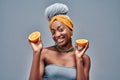 Portrait of half-naked afro american woman holding orange and smiling isolated over grey background Royalty Free Stock Photo