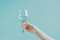 Portrait of Hand Holding Glass of Drink Copy Space on Blue Pastel Background Image Royalty Free Stock Photo