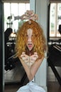 Portrait and hands of scary redhead woman with tongue out, creepy face in mirror, female duality, mental disorder, subconscious